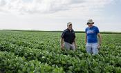 Steve Long and Don Ort stand in a soybean field.